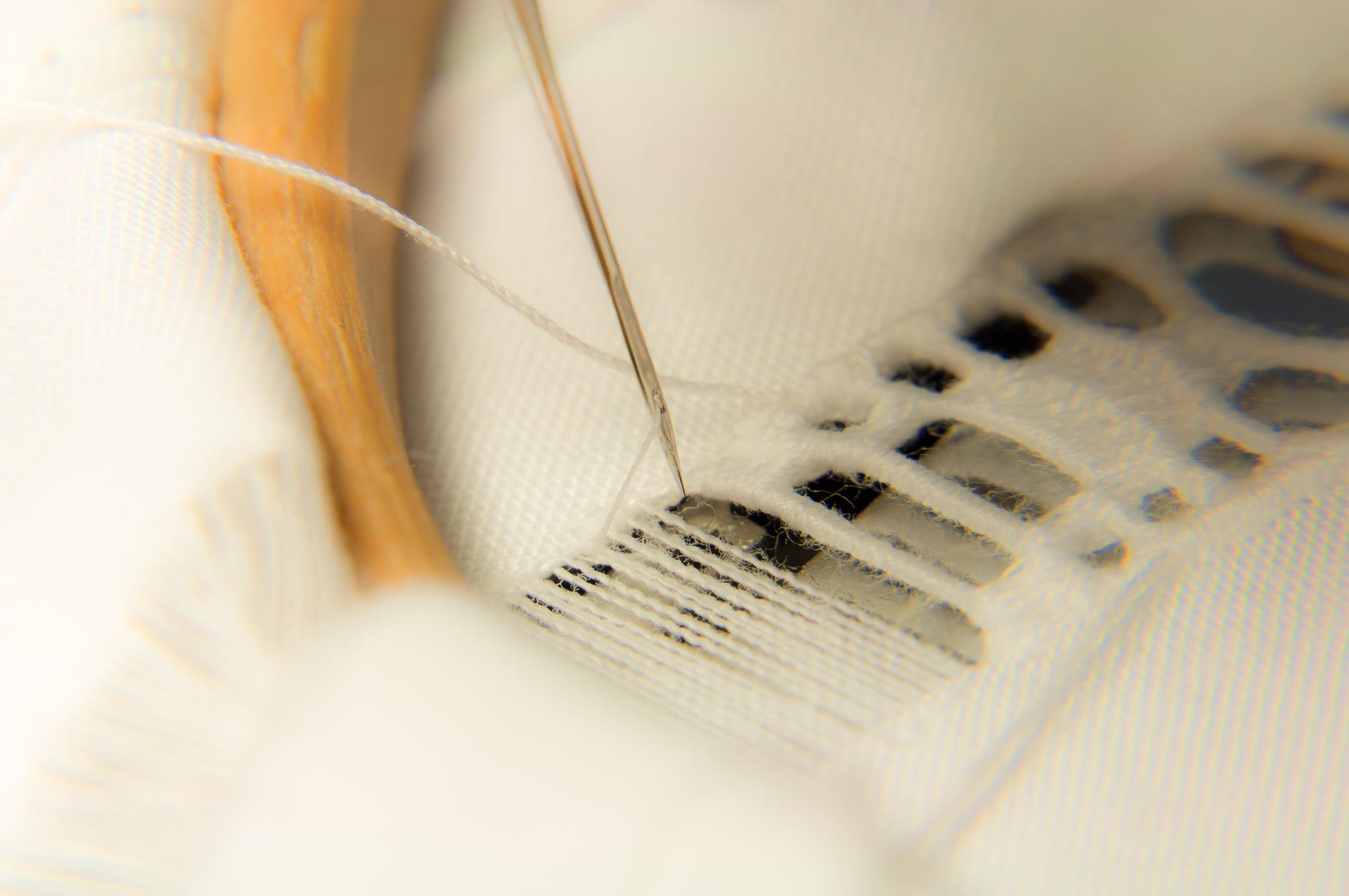 close-up of hand embroidery on linen with pastel threads